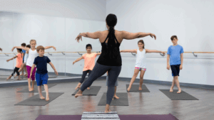 Yogalehrerin unterrichtet Kinderyoga in kleiner Gruppe